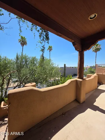 a view of a balcony with couches and wooden fence