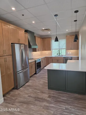 a kitchen with stainless steel appliances granite countertop a refrigerator a sink and a stove