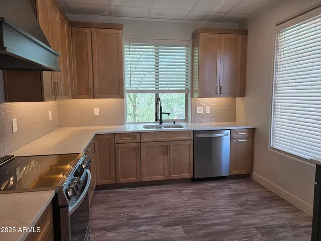 a kitchen with a sink a window and stainless steel appliances