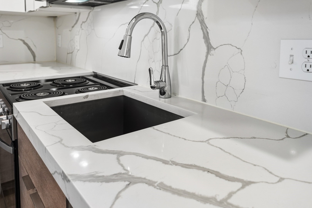 41 Wolcott Street, Unit 4 Everett, MA 02149 - Photo 12 of 19 a kitchen with a stove and white cabinets