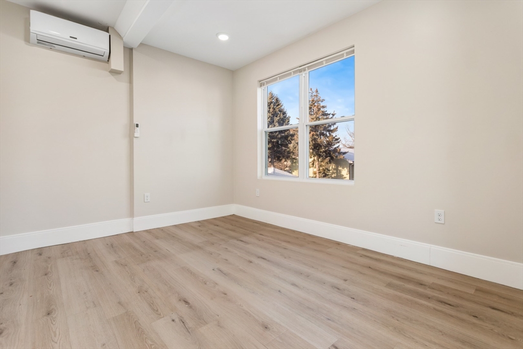 41 Wolcott Street, Unit 4 Everett, MA 02149 - Photo 6 of 19 an empty room with wooden floor and window