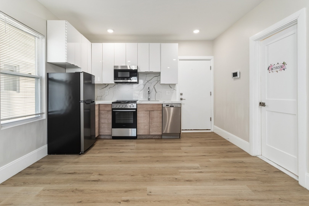 41 Wolcott Street, Unit 4 Everett, MA 02149 - Photo 10 of 19 a kitchen with stainless steel appliances granite countertop a refrigerator and a stove top oven