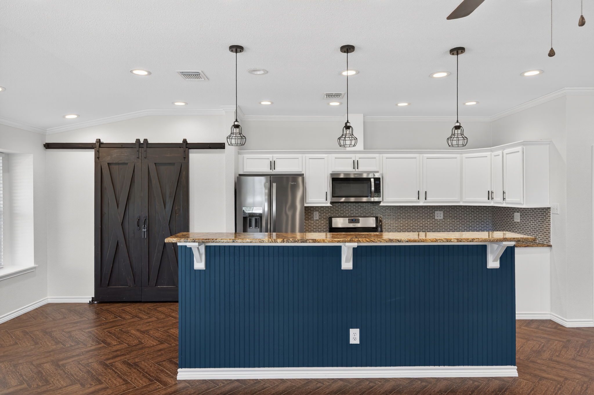 1201 Dillon Lake Bend Leander, TX 78641 - Photo 10 of 38 Kitchen featuring a kitchen bar, white cabinetry, stainless steel appliances, parquet floors, and light stone countertops