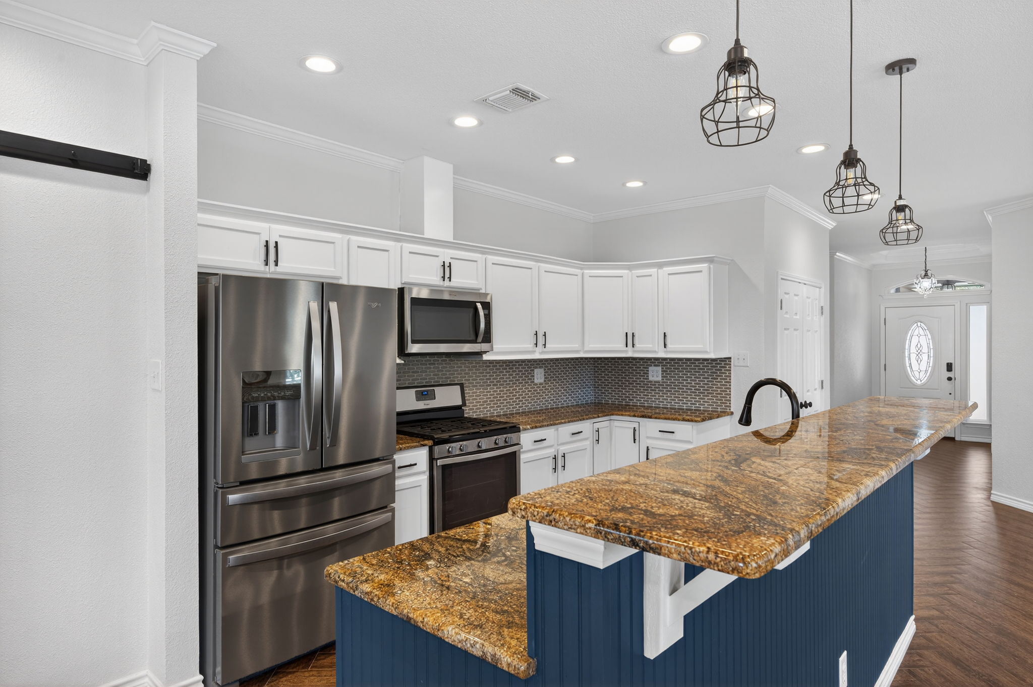 1201 Dillon Lake Bend Leander, TX 78641 - Photo 11 of 38 Kitchen with a breakfast bar area, white cabinetry, stainless steel appliances, dark stone counters, and parquet floors