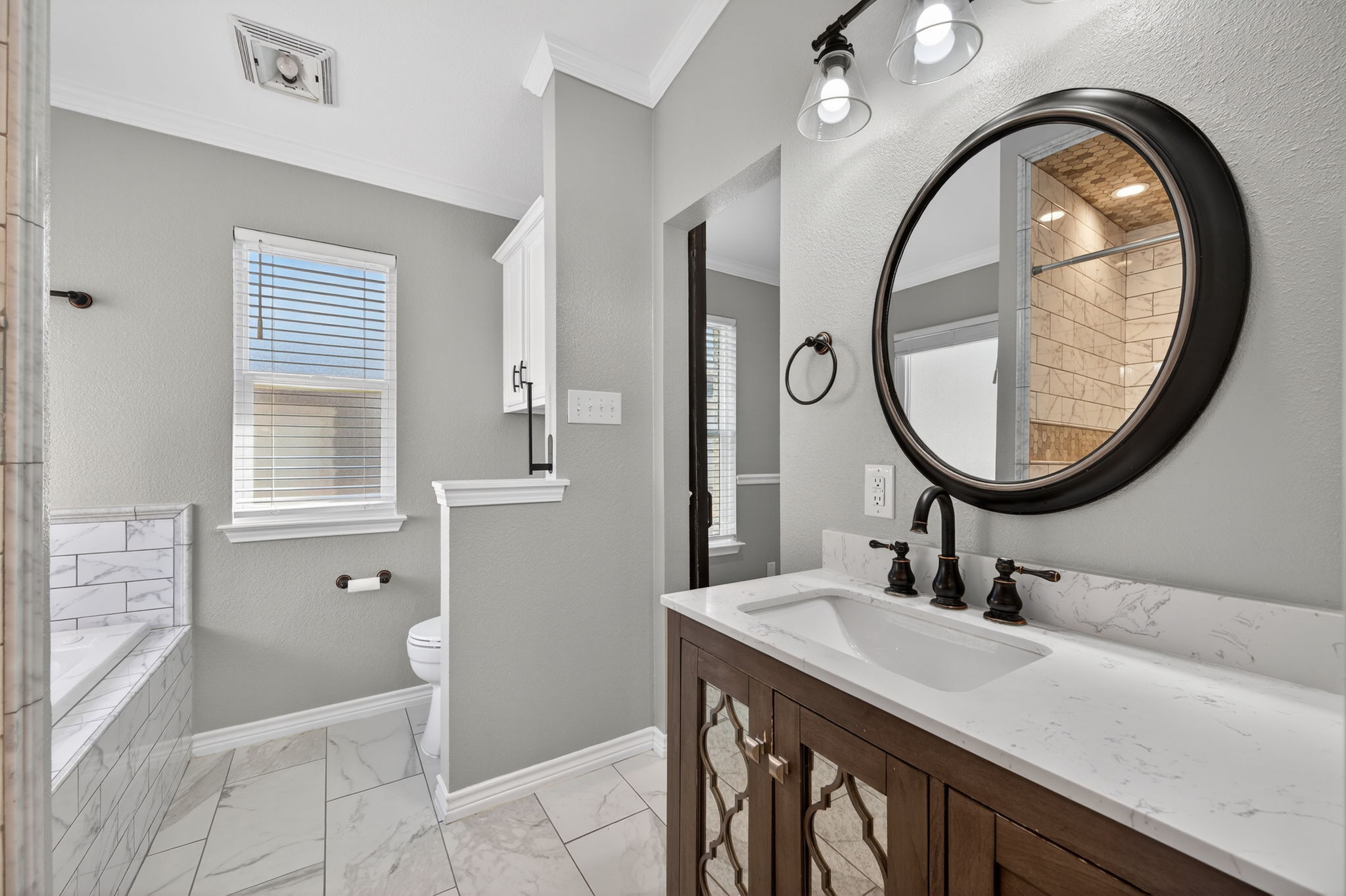 1201 Dillon Lake Bend Leander, TX 78641 - Photo 17 of 38 Bathroom featuring light marble finish floors, vanity, healthy amount of natural light, crown molding, and a bath