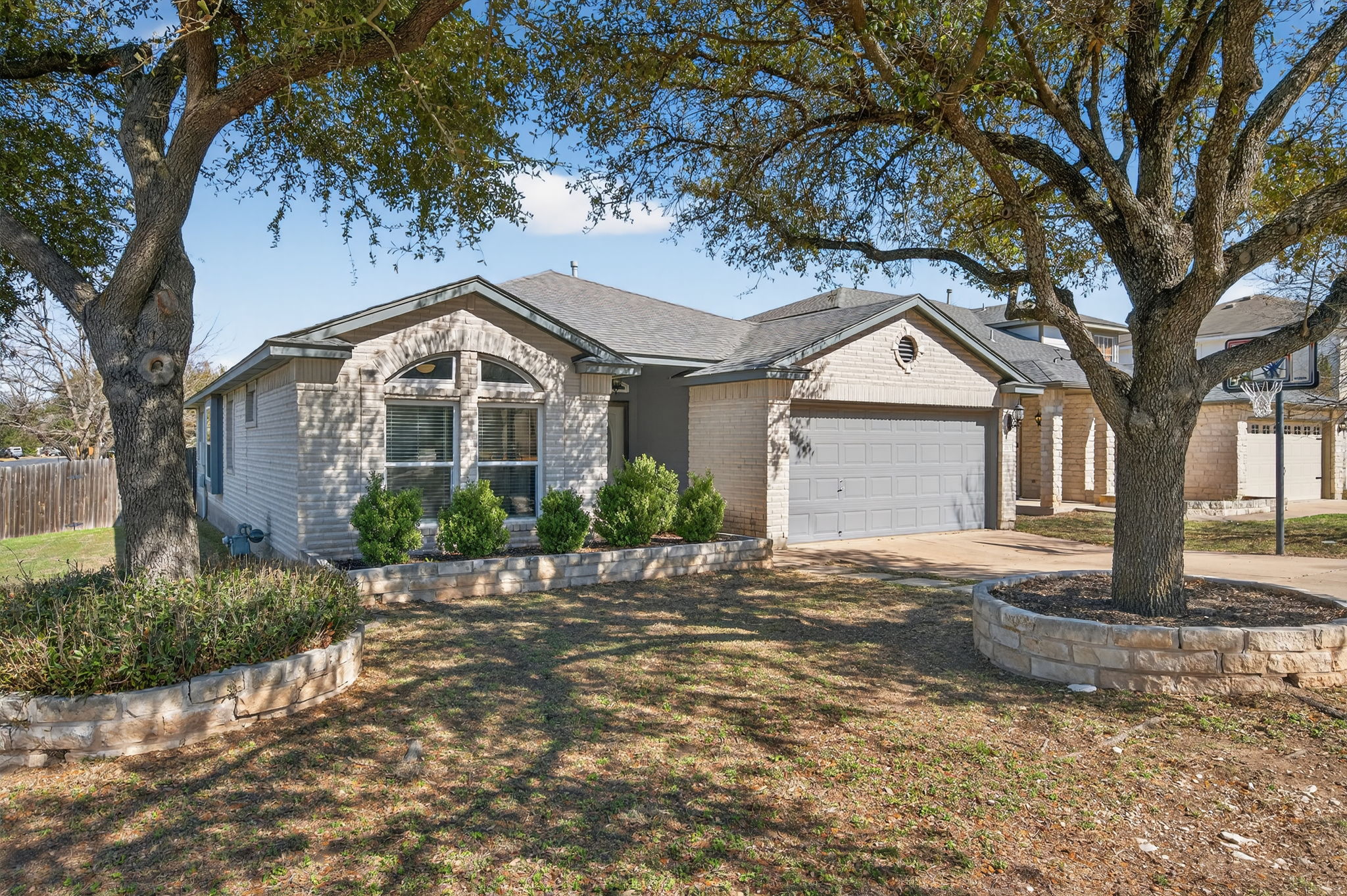 1201 Dillon Lake Bend Leander, TX 78641 - Photo 3 of 38 Ranch-style home with an attached garage, concrete driveway, and brick siding