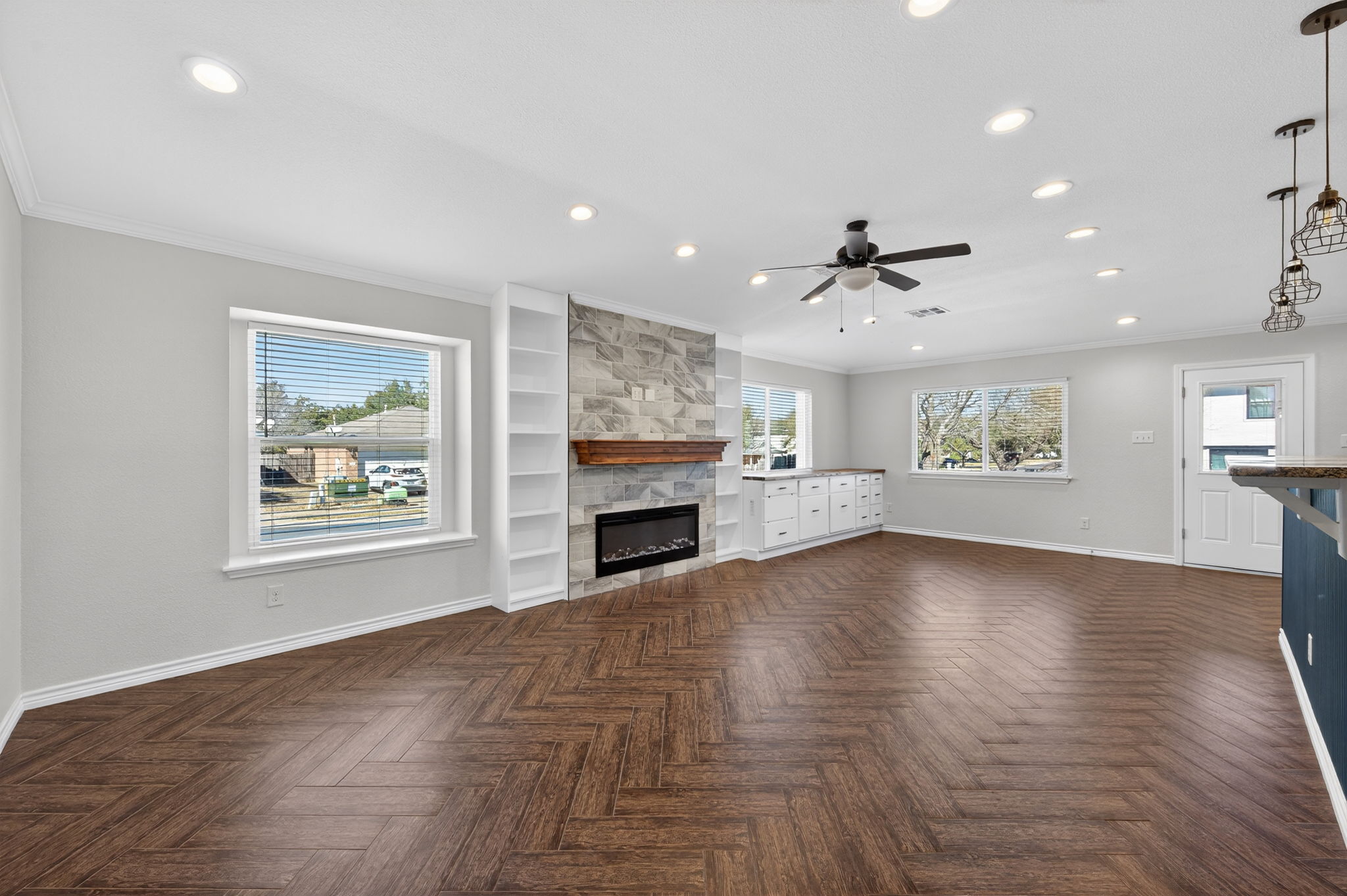 1201 Dillon Lake Bend Leander, TX 78641 - Photo 6 of 38 Living room with ceiling fan, parquet floors, a large fireplace, recessed lighting, and crown molding