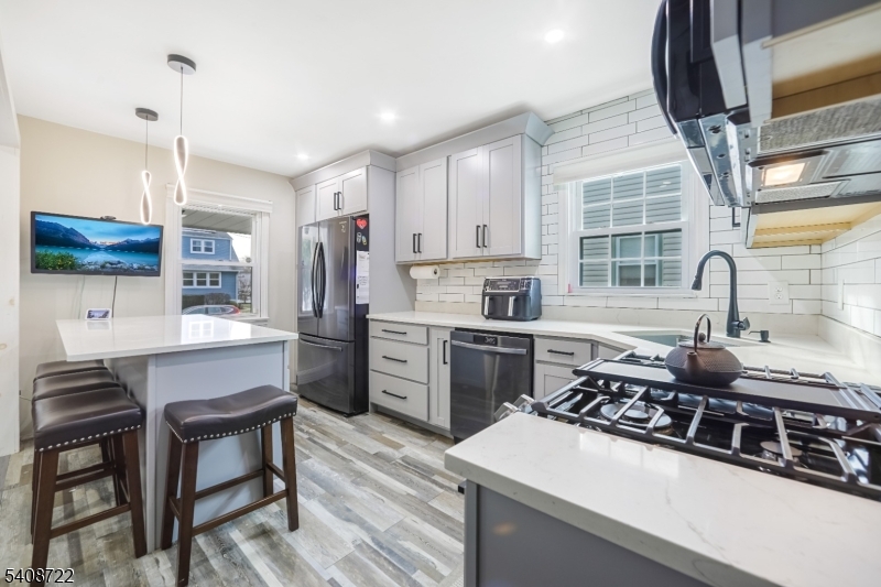 119 East 13th Street Linden, NJ 07036 - Photo 3 of 22 a kitchen with stainless steel appliances a stove a sink a microwave a refrigerator and cabinets