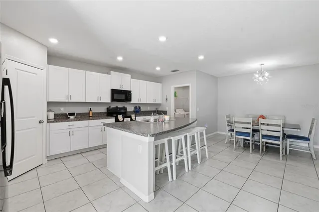a kitchen with a sink and chairs