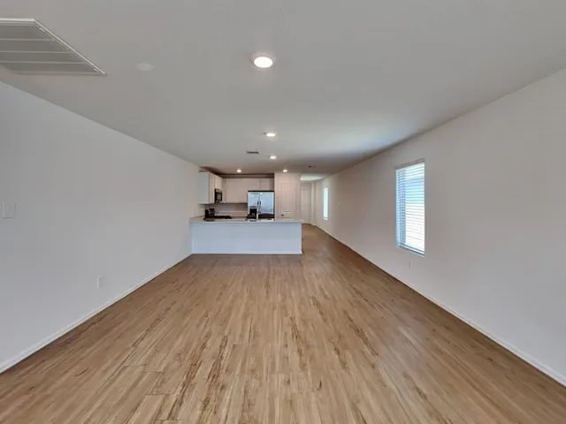 a large kitchen with stainless steel appliances granite countertop a stove and a wooden floors