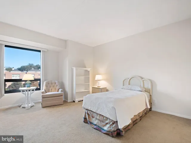 a spacious bedroom with a bed and glass wall