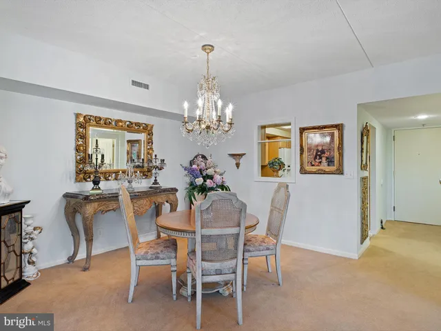 a dining room with furniture a chandelier and window