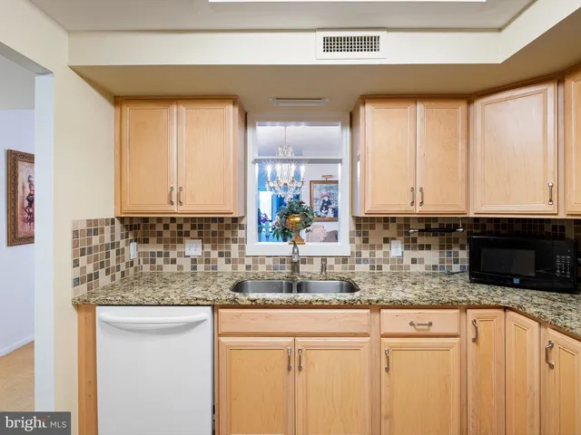 a kitchen with stainless steel appliances granite countertop a sink a stove and cabinets