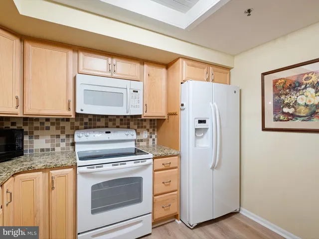 a kitchen with white cabinets and white appliances