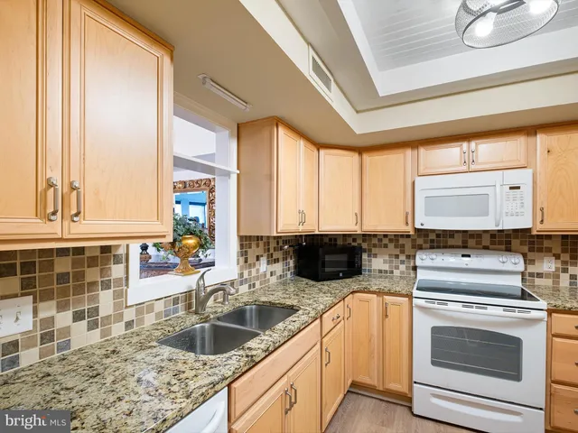a kitchen with a stove a sink and a cabinets