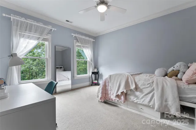 a spacious bedroom with a bed and large windows