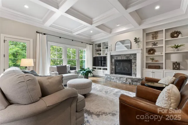 a living room with furniture fireplace and a large window