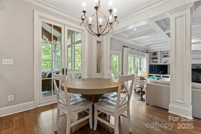 a view of a dining room with furniture a chandelier and wooden floor