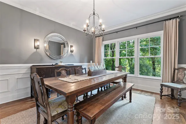 a living room with a table chairs and a large window
