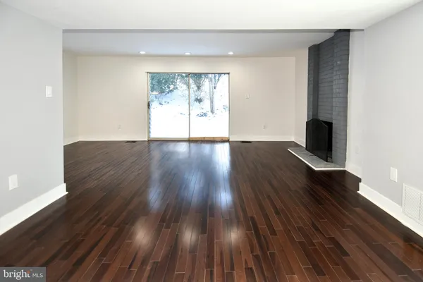 a view of a kitchen with wooden floor and a window