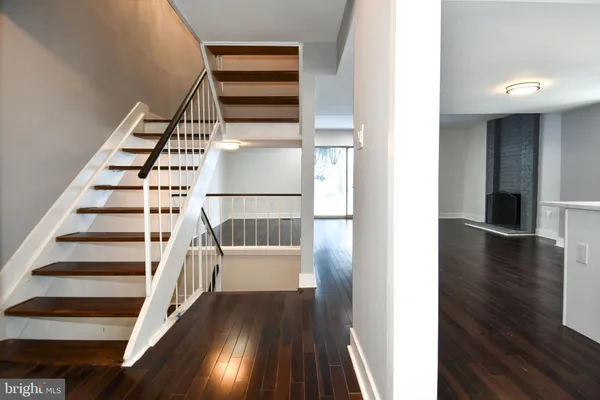 a view of a hallway with wooden floor and staircase