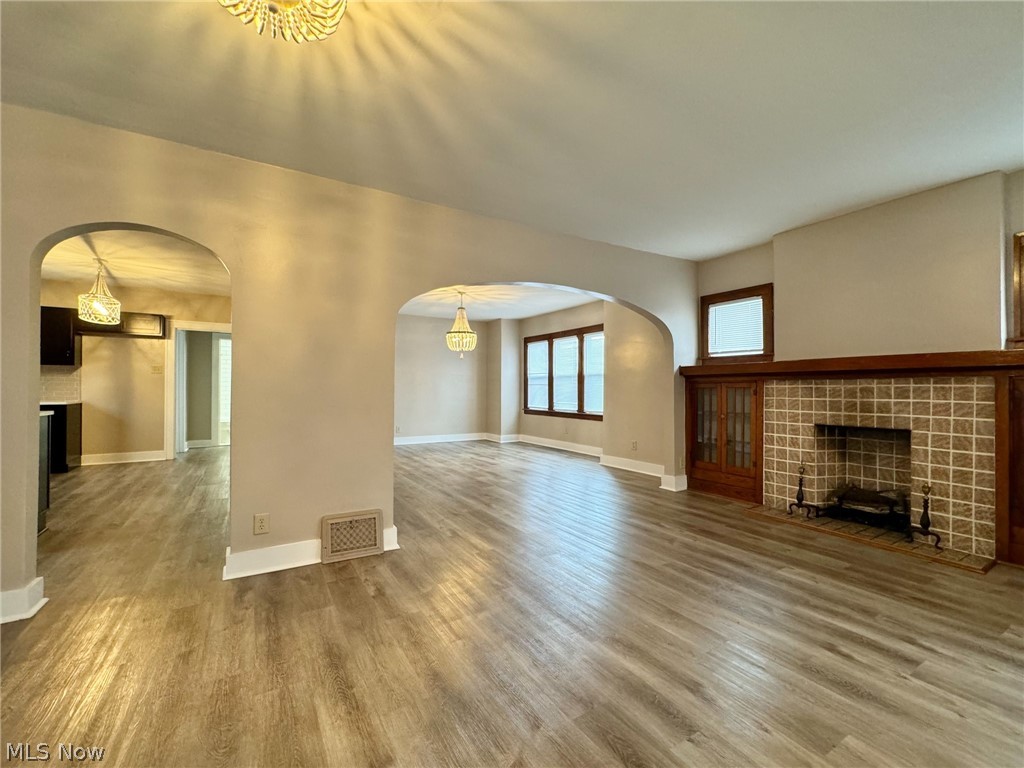Unfurnished living room featuring a tile fireplace and hardwood / wood-style floors