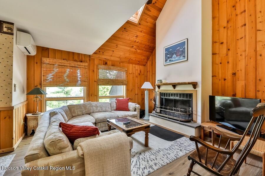 111 Brainard Ridge Road, Unit 11B Windham, NY 12496 - Photo 2 of 18 a living room with furniture a flat screen tv and a fireplace