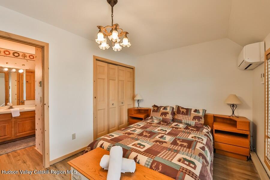 111 Brainard Ridge Road, Unit 11B Windham, NY 12496 - Photo 10 of 18 a bedroom with a bed and a chandelier
