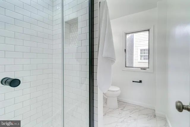 a bathroom with a toilet and a shower