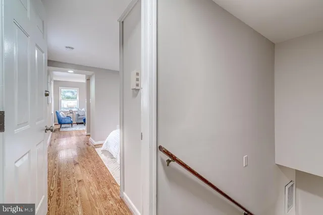 a view of a hallway with wooden floor and a living room