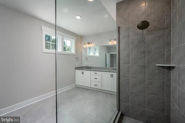 a bathroom with a granite countertop sink a shower and mirror