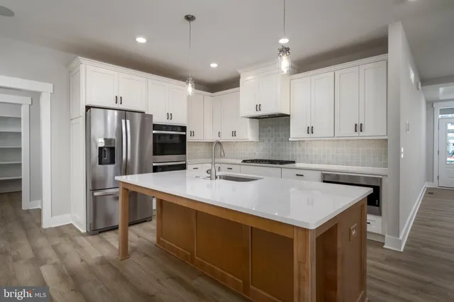 a kitchen with kitchen island a sink appliances and cabinets