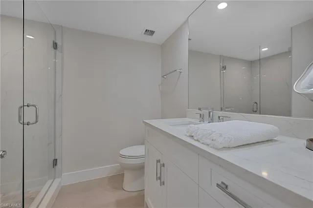 a bathroom with a granite countertop sink a toilet and a shower