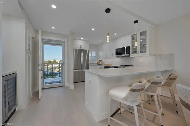 a kitchen with kitchen island stainless steel appliances a sink and a refrigerator