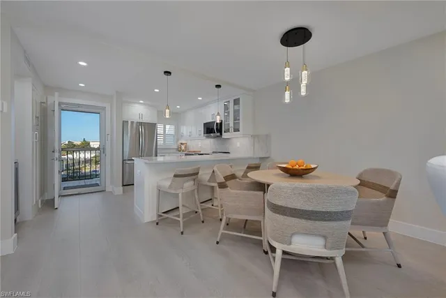 a kitchen with a dining table chairs and white cabinets