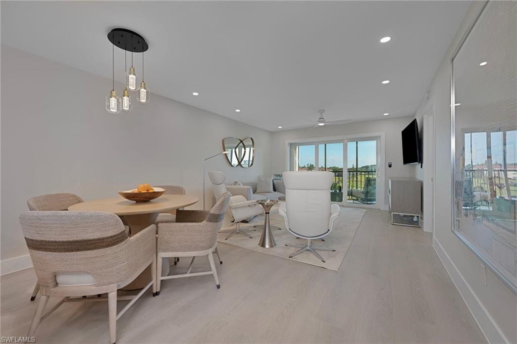 57 High Point Circle West, Unit 405 Naples, FL 34103 - Photo 8 of 15 a living room with furniture and a chandelier