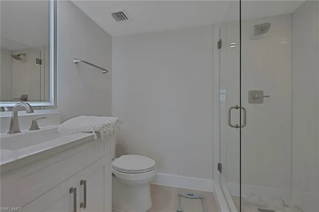 a bathroom with a granite countertop toilet and a sink