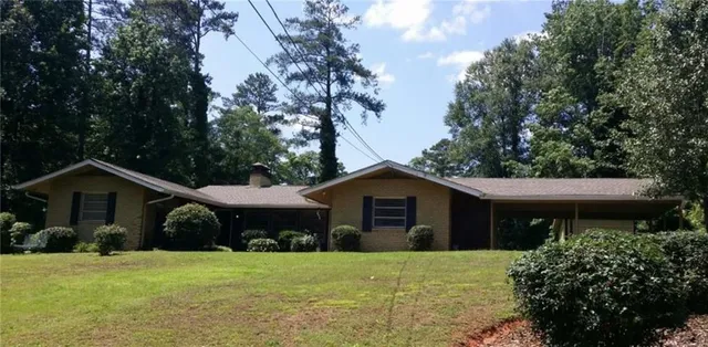 a front view of a house with a garden and trees