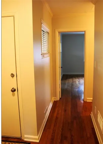 a view of a hallway with wooden floor