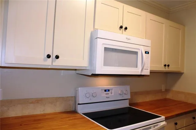 a kitchen with white cabinets and a stove