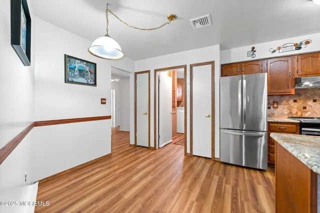 a kitchen with stainless steel appliances granite countertop a refrigerator a stove a sink and a refrigerator