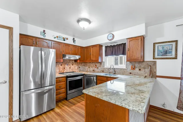 a kitchen with stainless steel appliances granite countertop a sink stove and refrigerator
