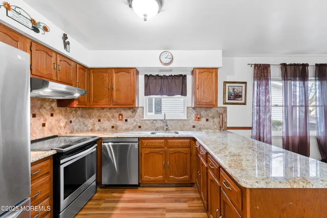 a kitchen with granite countertop a sink stove and cabinets