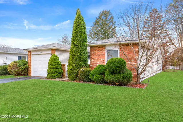 a view of a house with a yard and potted plants