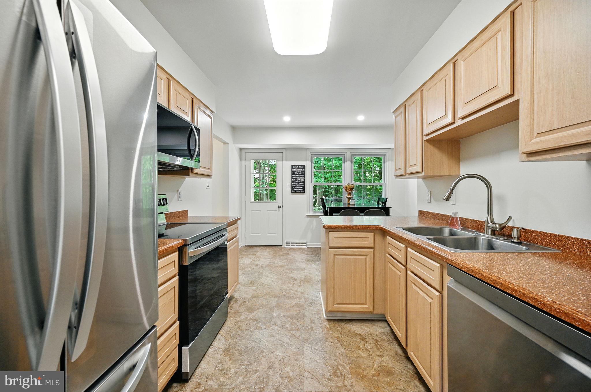 8923 Renshaw Court Springfield, VA 22153 - Photo 22 of 38 a kitchen with stainless steel appliances a sink stove refrigerator and a window