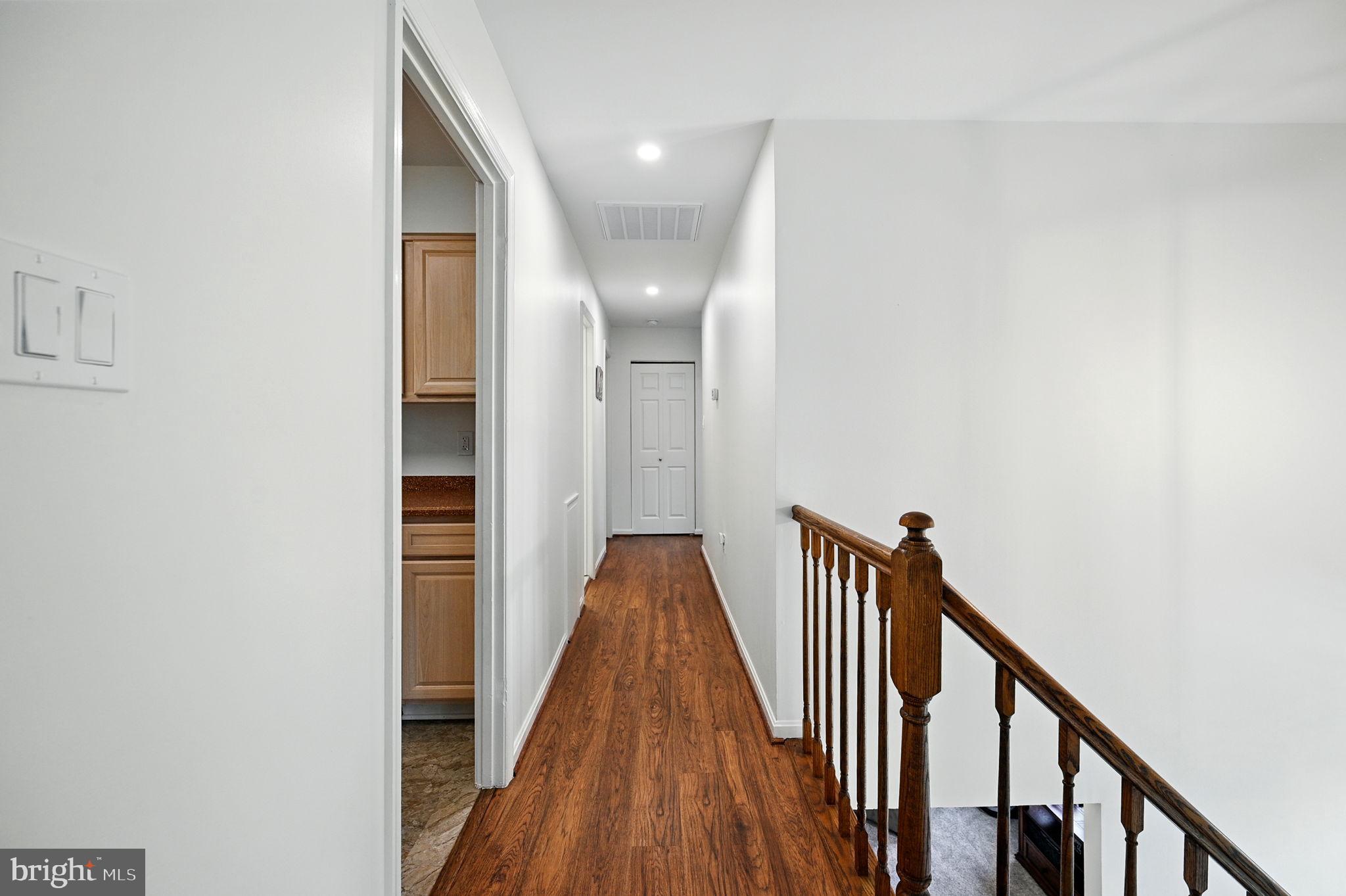 8923 Renshaw Court Springfield, VA 22153 - Photo 23 of 38 a view of a hallway with wooden floor and staircase