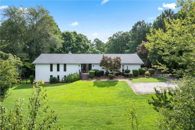a view of a house with pool and a yard