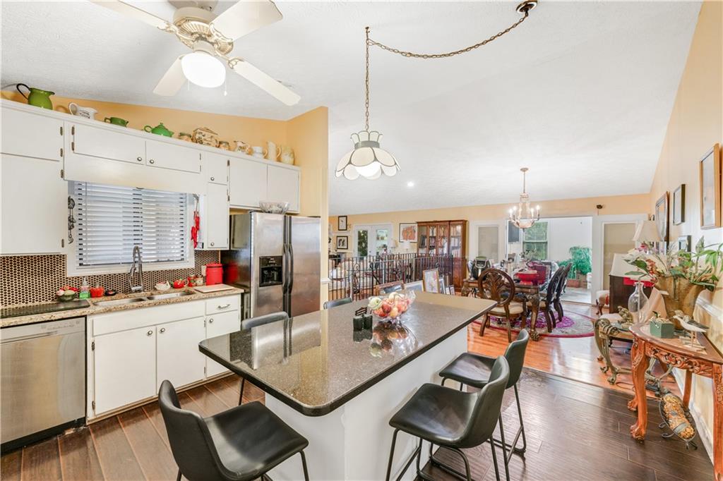 3960 Highway 20 Conyers, GA 30013 - Photo 11 of 57 a room with stainless steel appliances kitchen island granite countertop a table chairs and a view of living room
