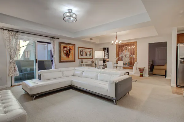 a view of a dining room with furniture a chandelier and wooden floor