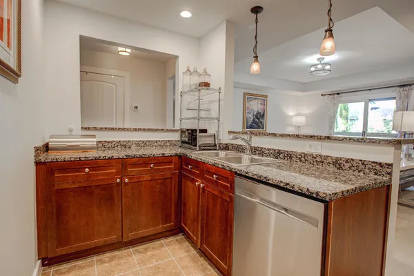a kitchen with granite countertop a refrigerator stove and microwave